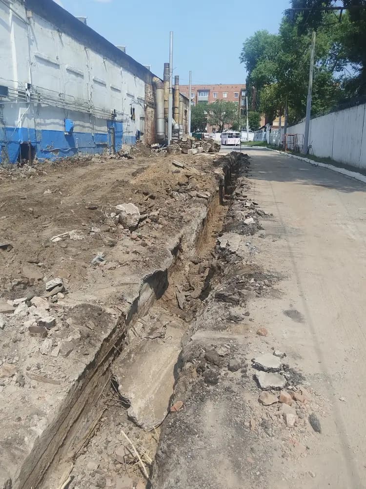 Вскрытая траншея вдоль здания