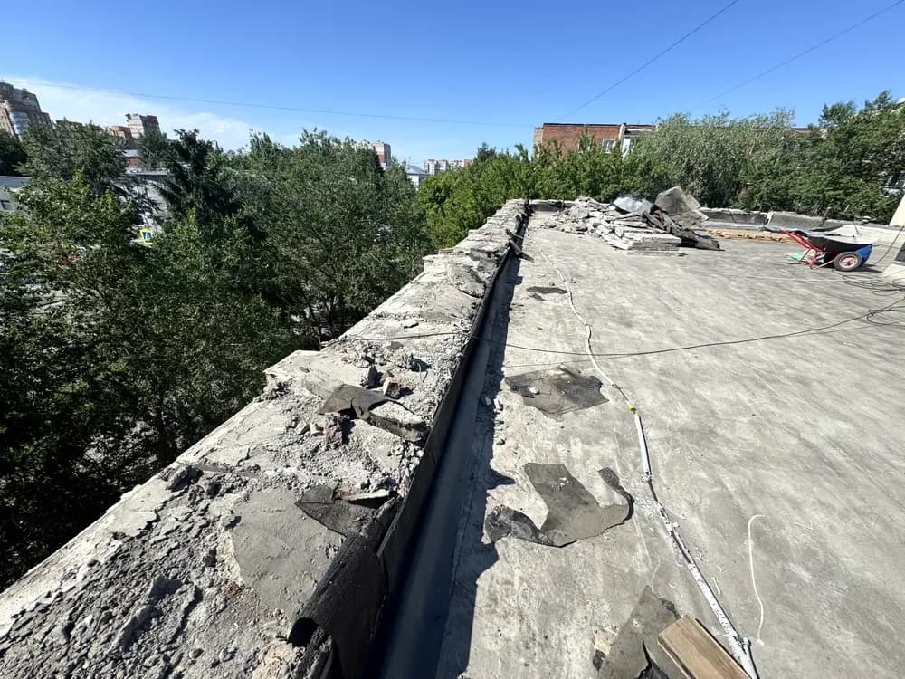 Старое рулонное покрытие с трещинами и заплатами до ремонта
